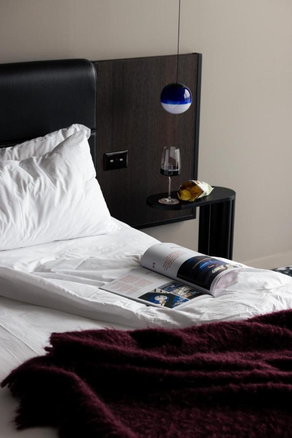 Ebb-Dunedin Kültér fotó A bed with a magazine and a wine bottle